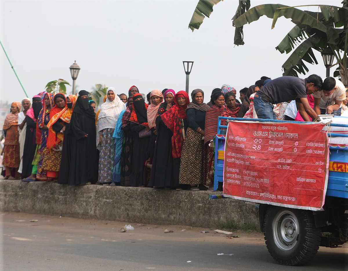 ওএমএসের পণ্যবাহী গাড়ি থেকে পণ্য কেনার জন্য সারিবদ্ধভাবে দাঁড়িয়েছেন তাঁরা। ঝালোপাড়া, সিলেট, ৫ ফেব্রুয়ারি